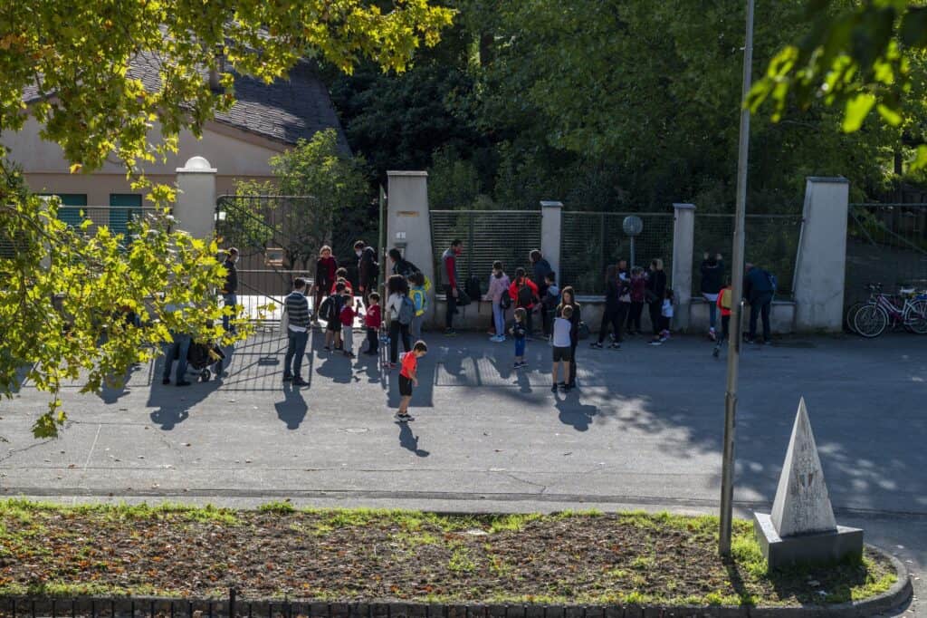 Children with their parents about to enter the school