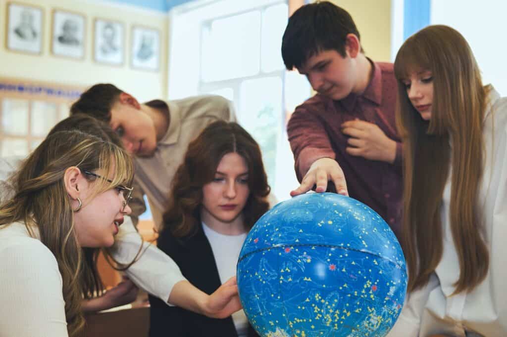 Students inspecting a globe model